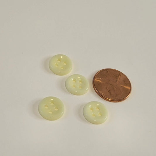 Pale yellow 12mm porcelain buttons beside a penny for size reference
