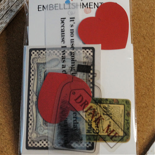 Front view of packaged Alice in Wonderland Mini Kit with Embellishmentals label, red heart tags, vellum quote, and printed card designs.