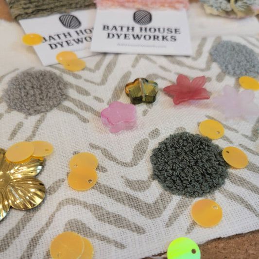 Close-up of Wildflower embellishments pack with chenille medallions, lucite flower beads, gold flower sequins and yellow paillettes on botanical fabric