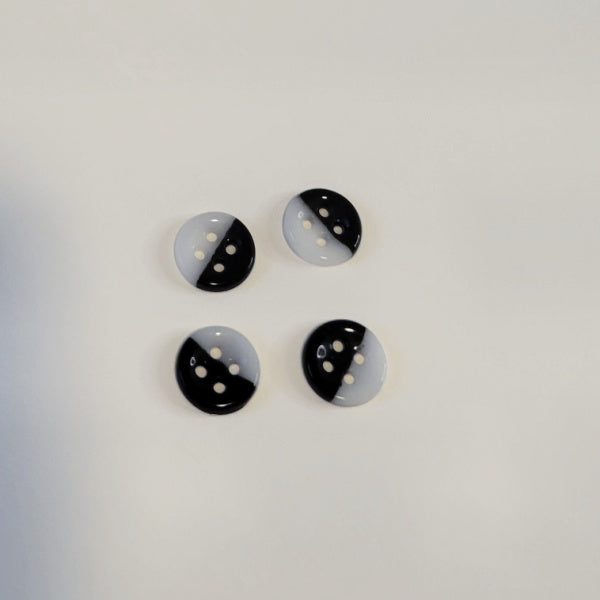 Four black and white porcelain buttons on a light gray background