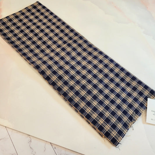 Wide view of the woven navy blue and warm tan plaid pattern vintage cotton homespun fabric