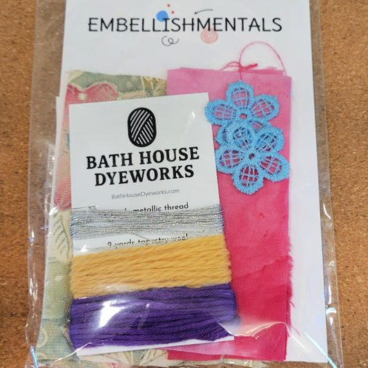 Packaged fabric sampler pack from Bath House Dyeworks with colorful threads and a decorative hand dyed lace flower with hand dyed fabric and vintage kimono silk